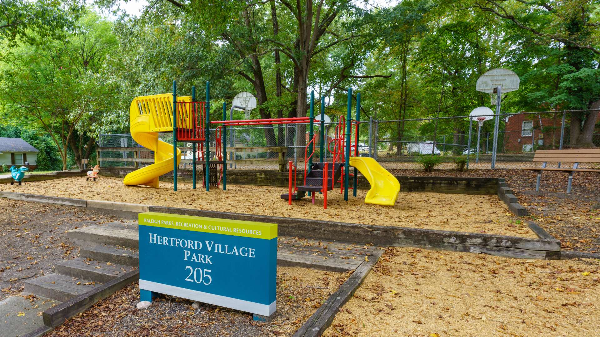 Playground with basketball court behind it