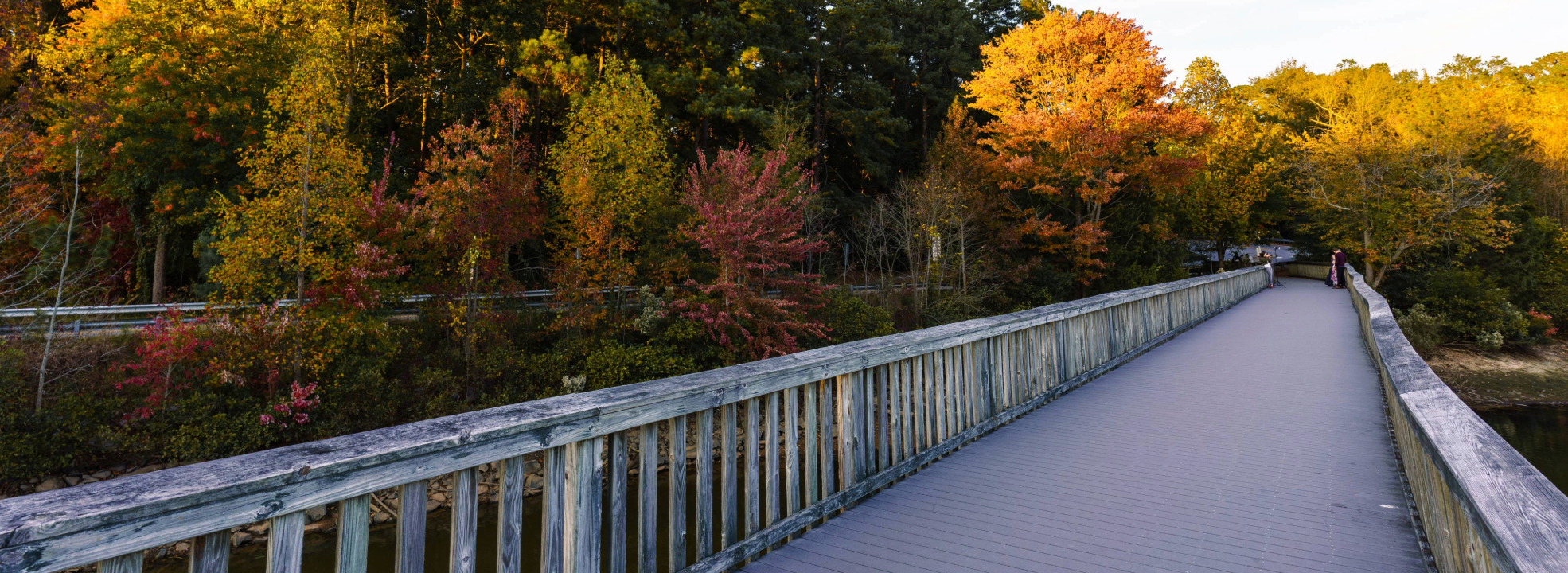 Wooden greenway bridge with fall-colored leaves