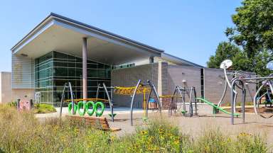playground with monkeybars and other climbing equipment at the front of the Halifax Community Center