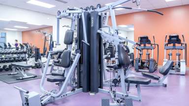 A fitness room with machines, free weights and cardio equipment 