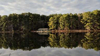 Lake view at Durant Nature Preserve with trees and cabin