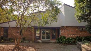 Brick community center with large tree in front
