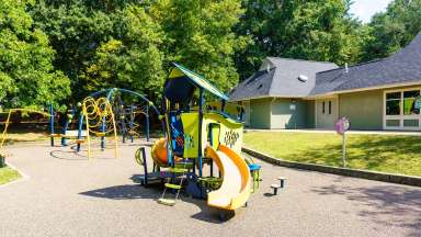 Powell Drive Park with community center in background and playground in foreground