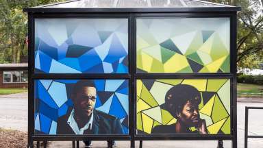 Bus shelter wrapped in art by Kiara Sanders titled "Nina, a Monk, and a Trane". Located at Pecan Road at S. Saunders St.