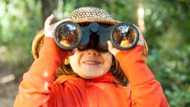 young child with binoculars