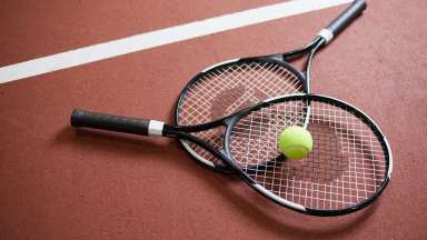 Two tennis racquets with a tennis ball