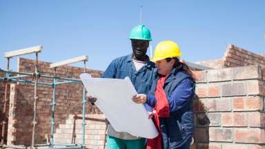 man and woman on construction site looking at site plans