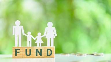 Human cutouts standing over blocks that spell fund