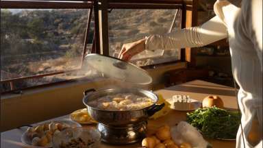 photograph of a person working with food in front of a window.