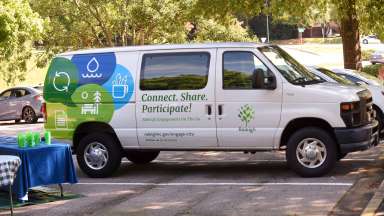 Cargo van with "Connect. Share. Participate" and Raleigh branding parked