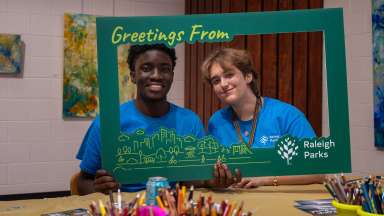 summer camp employees with a picture frame cutout