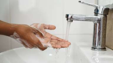 Hands with soap over sink