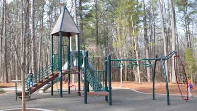 a playground with a slide and small jungle gym