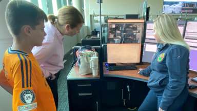 Mom, son, and 911 call taker looking at computer screens.