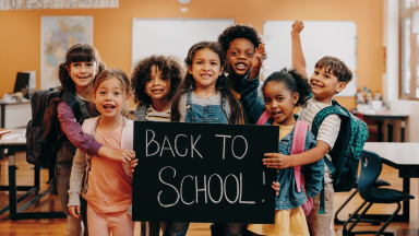 Young children holding a back to school sign