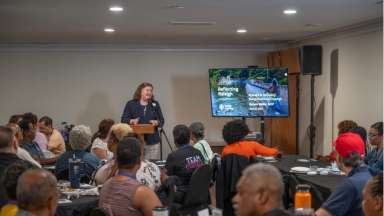 Speaker presenting to a group of seated audience members