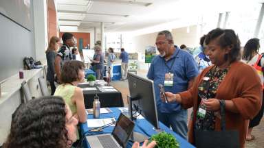 Two people speaking to event hosts at table