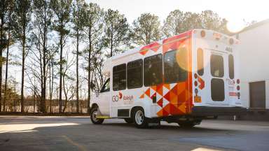 An access transit vehicle decorated in red and orange triangles.