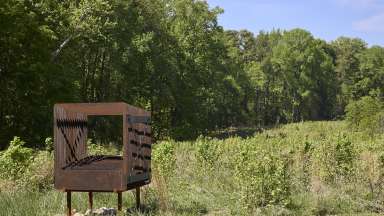 A metal sculpture stands in a meadow