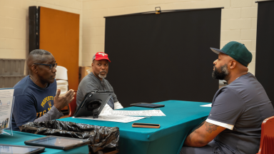 Men sitting at a table at the Men's Health Event