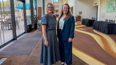 Two staff members smiling inside performing arts center