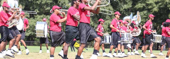 School band in formation wearing red shirts and black shorts