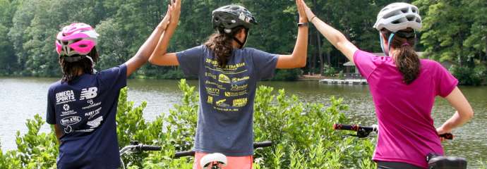 three teens on bikes sharing hi-fives