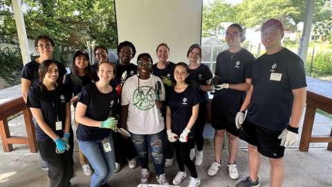 Group of young adults wearing City of Raleigh t-shirts pose for a photo