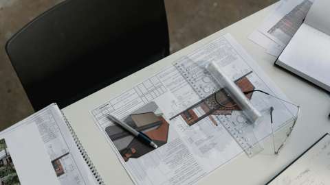 Building plans are displayed on a desk.