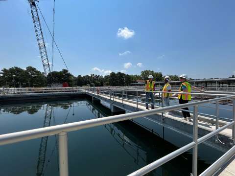 Three workers overseeing water treatment process