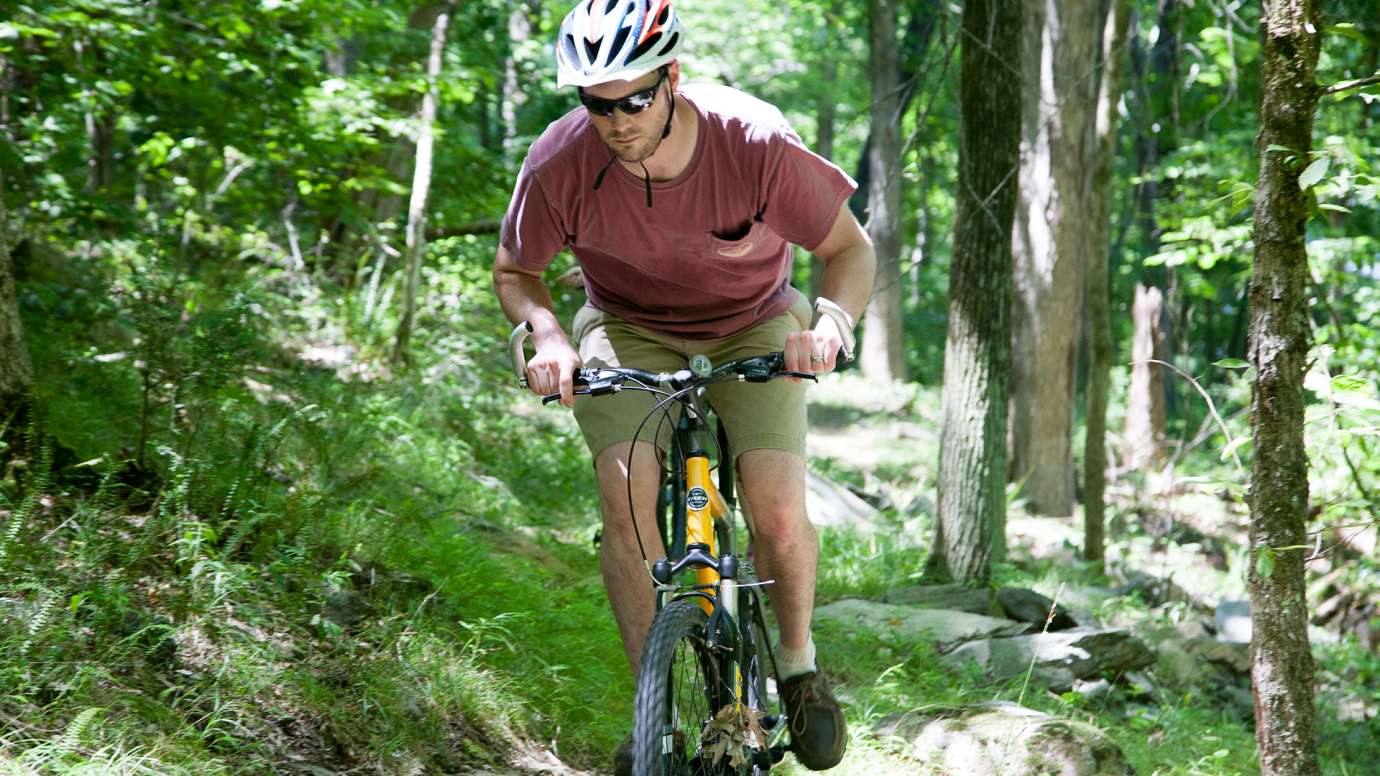 Man mountain biking on trail