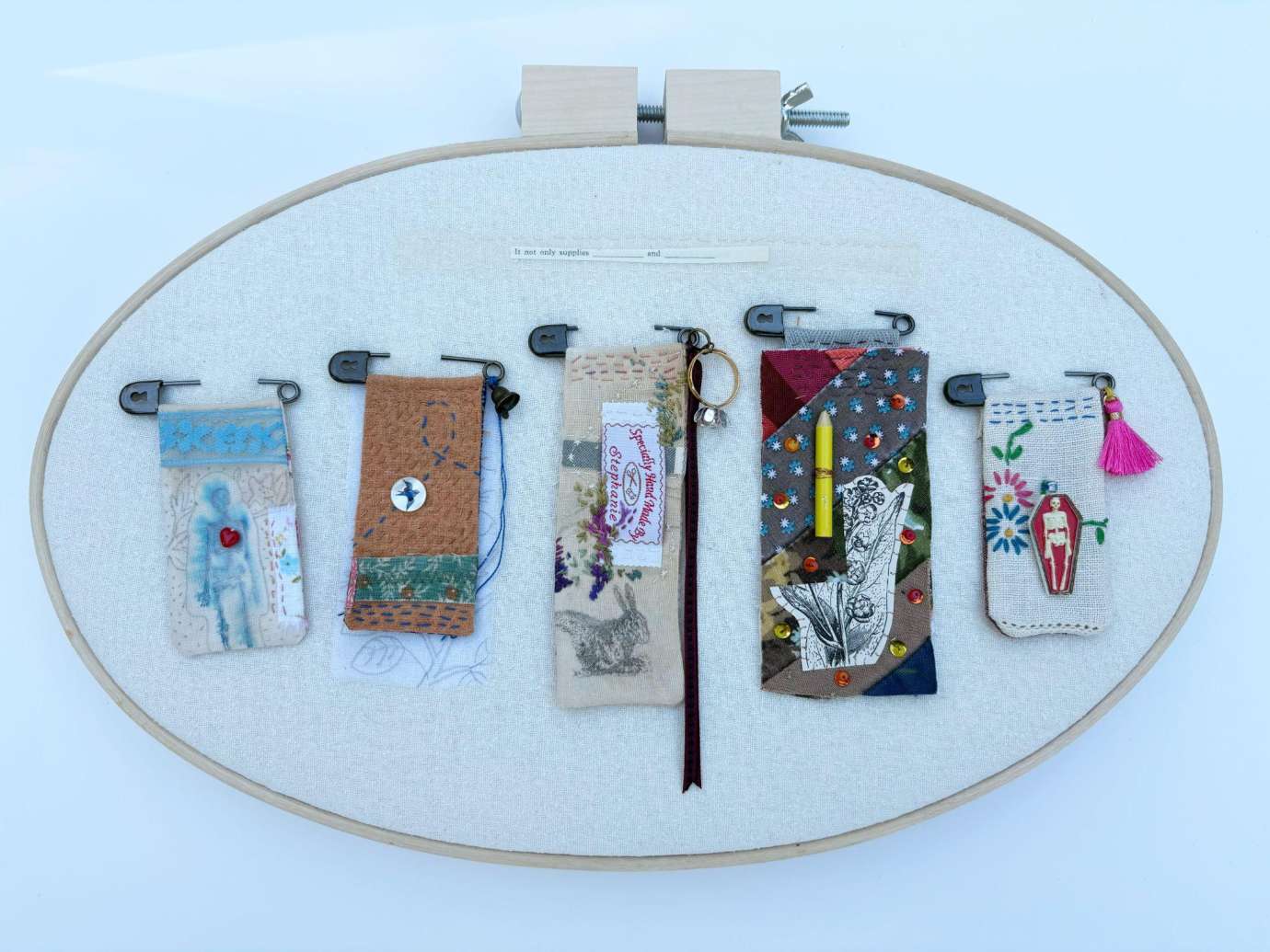 Oval embroidery hoop with small handstiched images.