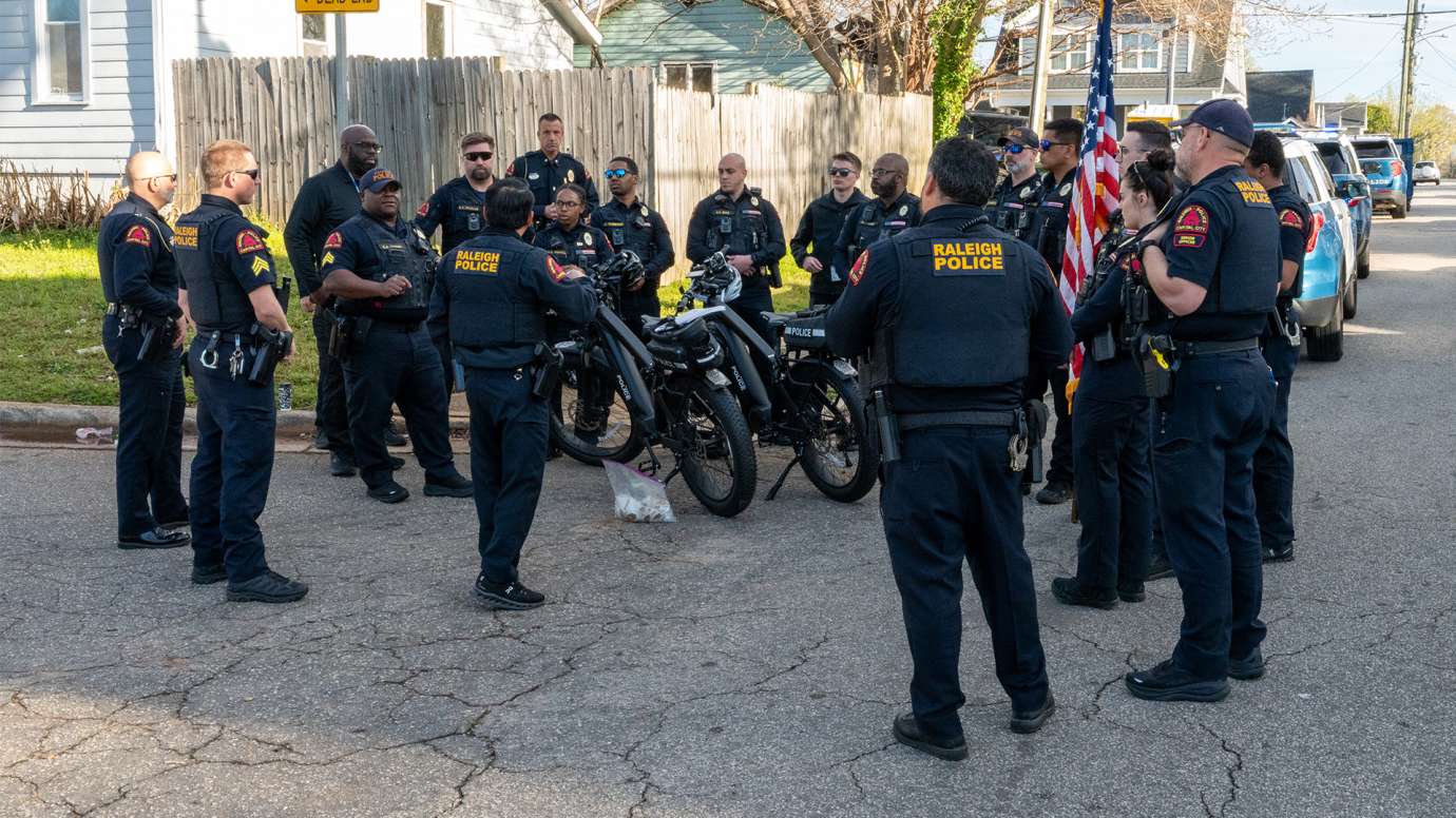 Raleigh officers gather on the street during a Cops on the Block event.