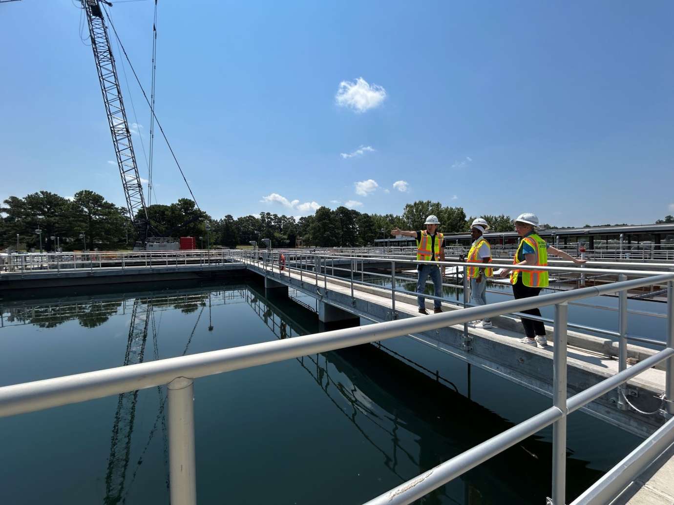 Three workers overseeing water treatment process