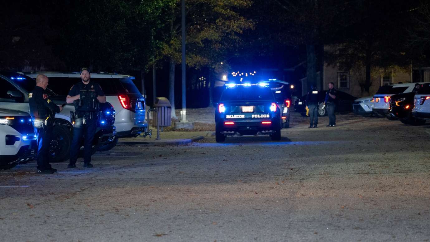 RPD officers standing next to police vehicle at night