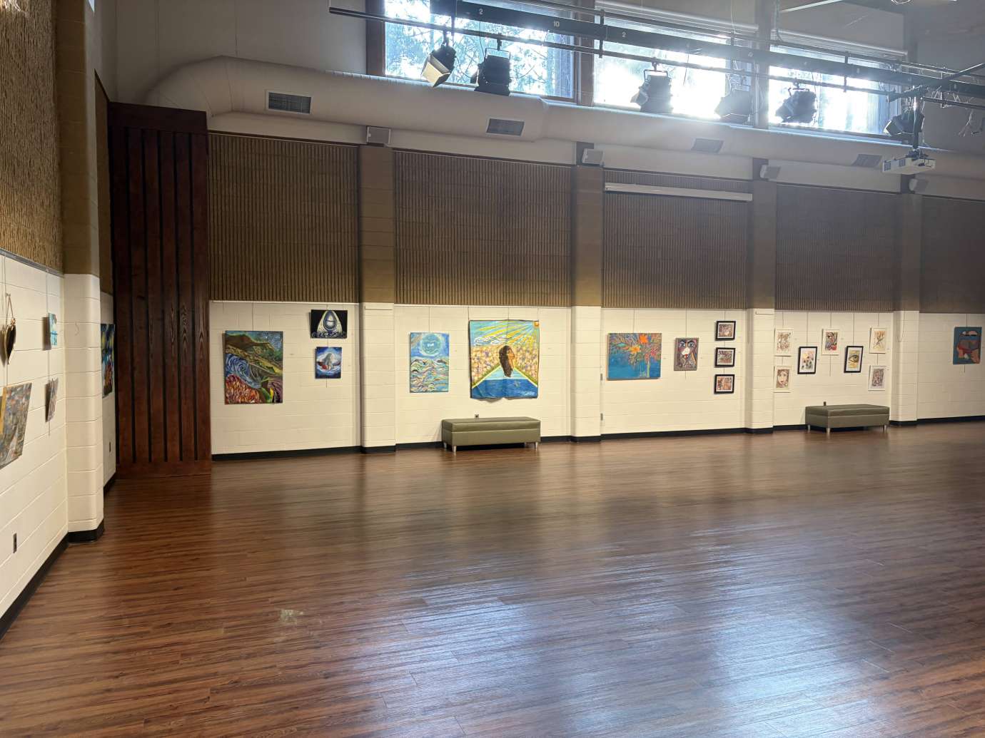 Colorful paintings hanging on white walls in a large room 
