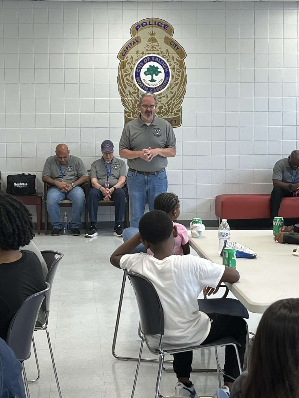 Person standing and talking to seated children