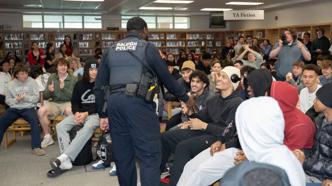 Police officer shaking hands with student