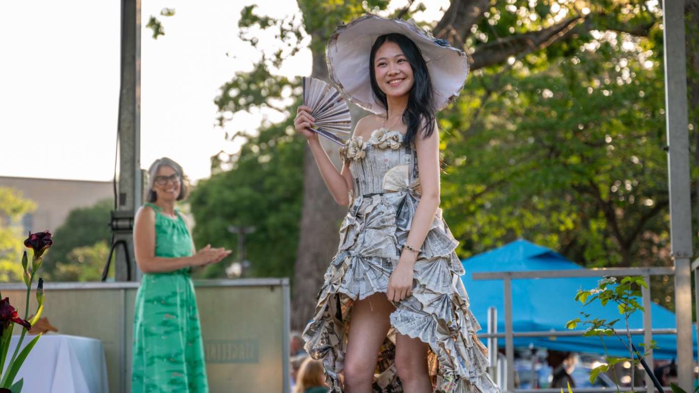 Girl in dress waving a paper fan