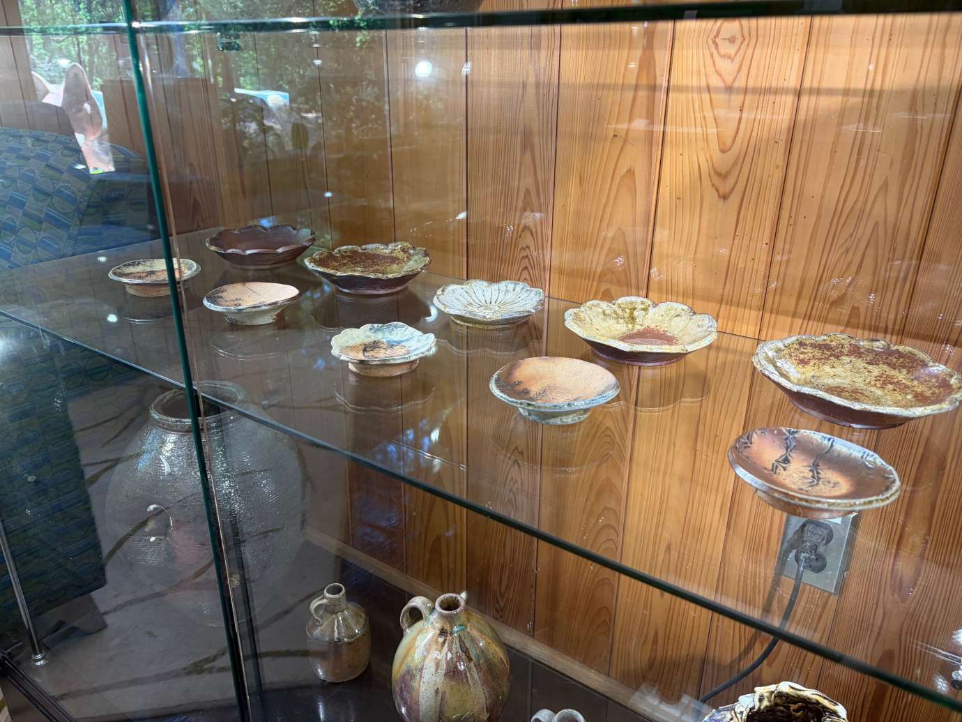 Pottery by Heather Lee McLelland in a glass display case 