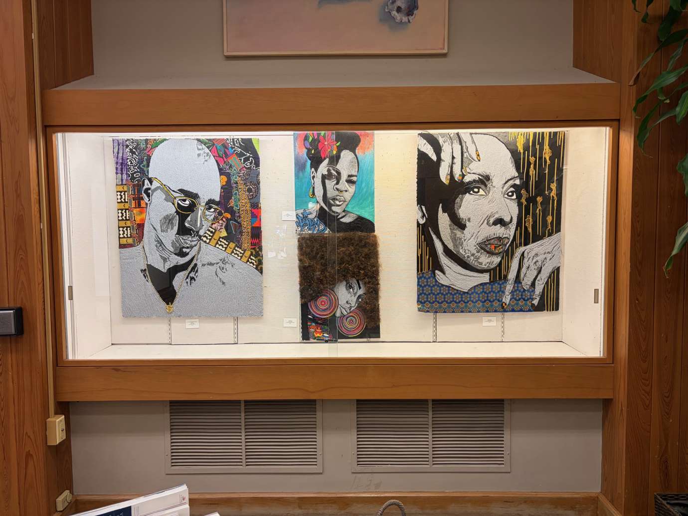 Works by Linette Knight hanging in a glass display case 