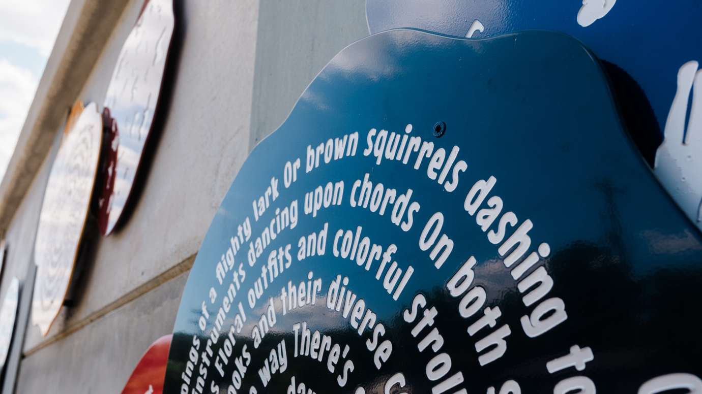 Close up on a metal disc that has poetry on it