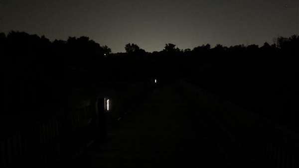 a greenway trail bridge at night with solar lights at 20% luminosity