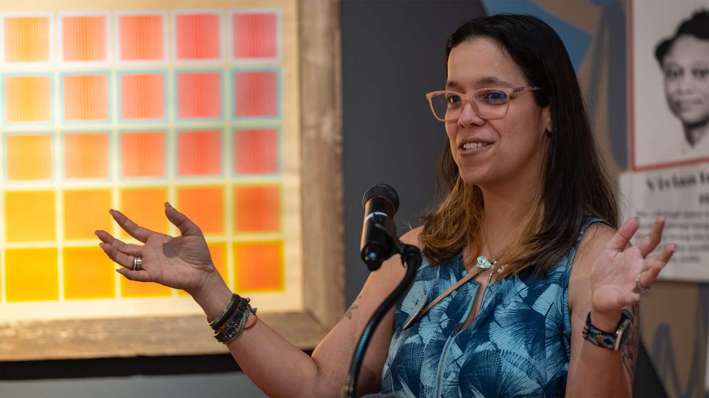 a person standing behind a microphone speaking