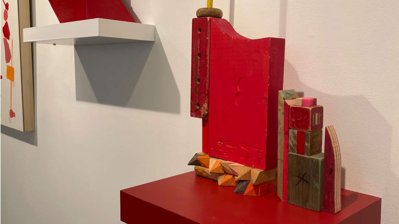 Close up of a primarily red wooden mixed media sculpture by Jason Lord