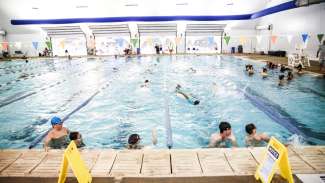 People swimming, splashing and playing at indoor Millbrook Exchange Pool