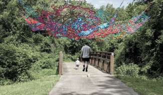 A weaving is suspended above a greenway
