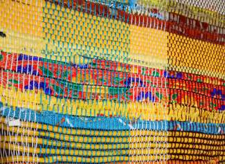 A colorful weaving that incorporates thread and plastic bags