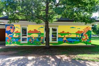 The mural shows active adults cycling and enjoying the outdoors