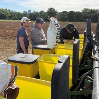 three men loading a planter with seed